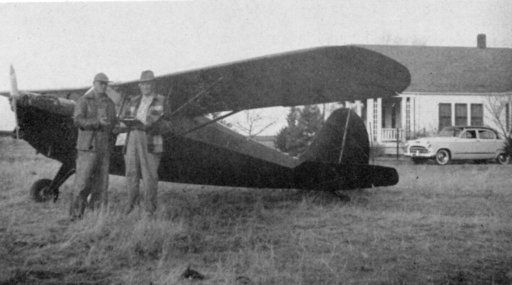 Stanley Smrcka, Grant County’s flying farmer-insurance agent, is shown here as he finishes filling out the application for insurance on Frank Krejsek’s new automobile, parked near Krejsek’s home.