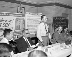 On July 10, 1958, members of Farm Bureau counties in western Oklahoma held this Meet the Candidate forum with two runoff candidates for the democratic nomination for congressman. Congressman Toby Morris (second from left) and challenger Victor Wickersham (second from right) were guests of 100 leaders from 17 western counties of Oklahoma’s Congressional District 6, shown here with OKFB President Lewis H. Munn (at microphone). The candidates were quizzed about their beliefs on 13 different issues and government philosophies in order to compare them against Farm Bureau policy.
