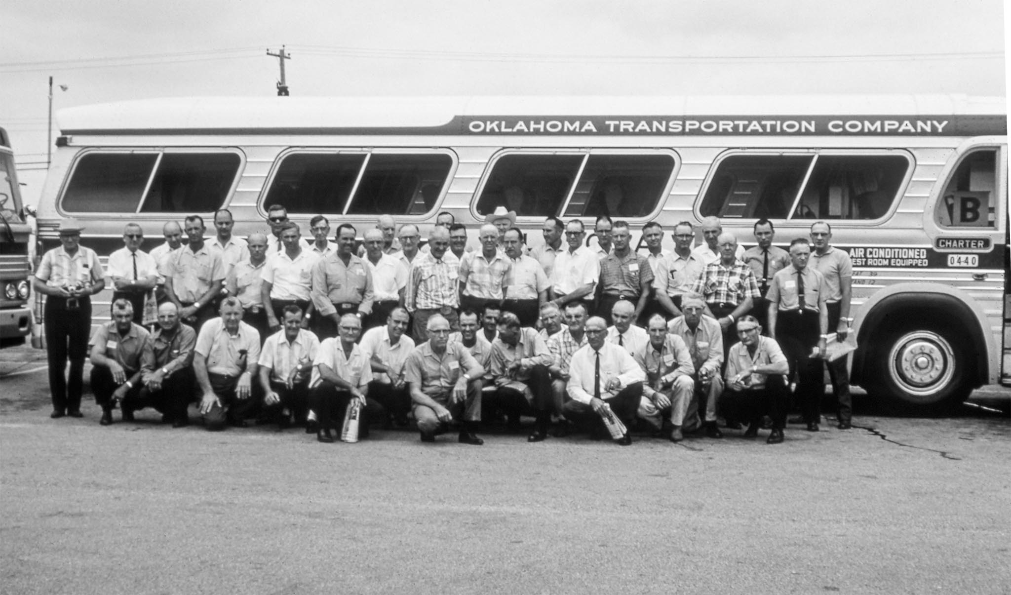 Fifty-two Oklahomans participated in a three-state Farm Bureau leaders tour in July, joining fellow FB leaders from Texas and Artkansas on a five-day tour of county farm bureaus in Kansas, Iowa, and Illinois. Shown here by one of the two buses are the county leaders, state board members and enough staff members to handle the necessary details.
