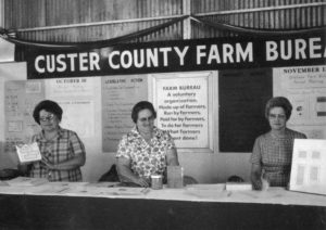 This fair booth was in Custer County in 1967. Tending to the booth are Mrs. Steward Barrick, Mrs. Con Burgtorf and Mrs. Tony Murray, who placed special emphasis on the legislative and policy development programs of Farm Bureau and information aids used to keep members informed.