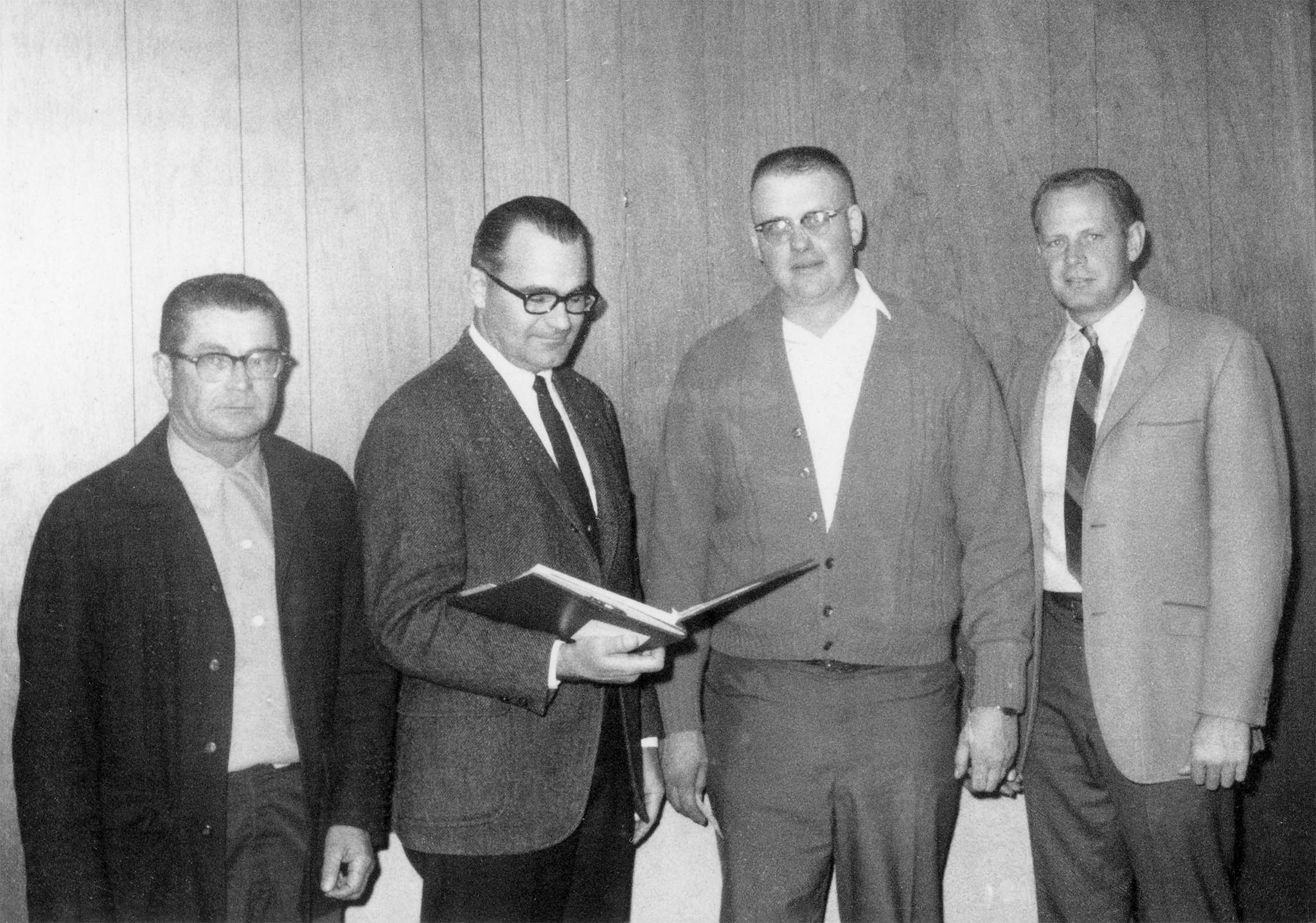 In 1968, Texas County was the focal point of a silage survey conducted by the American Agricultural Marketing Association as part of a multi-state study of silage marketing. Shown looking over some of the data gathered in the survey are Norman Hinds, Texas County Farm Bureau Board member; Tom Bennett, AAMA research staff member; Ronald Wagner, Texas County Farm Bureau President; and Virgil Higgins, Texas County Farm Bureau Board member.