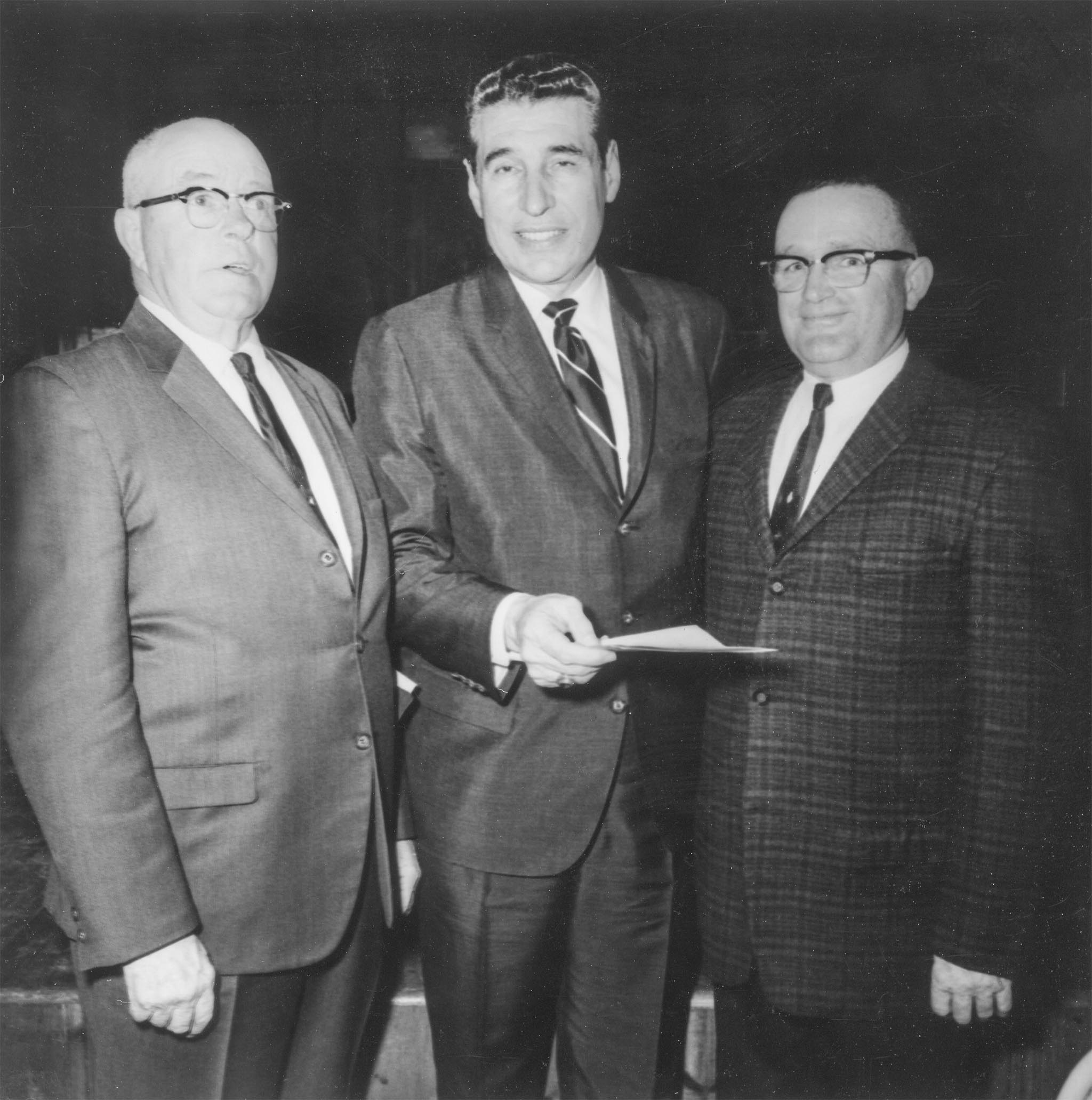 This 1968 photo, taken at the Garvin County Farm City dinner, features Dr. Robert B. Kamm, President of Oklahoma State University (center), discussing current issues with A.J. Chapman, Garvin County Legislative Chairman (left), and O.W. Parker, Garvin County President. Kamm was the principal speaker for the 300 people who attended the dinner.
