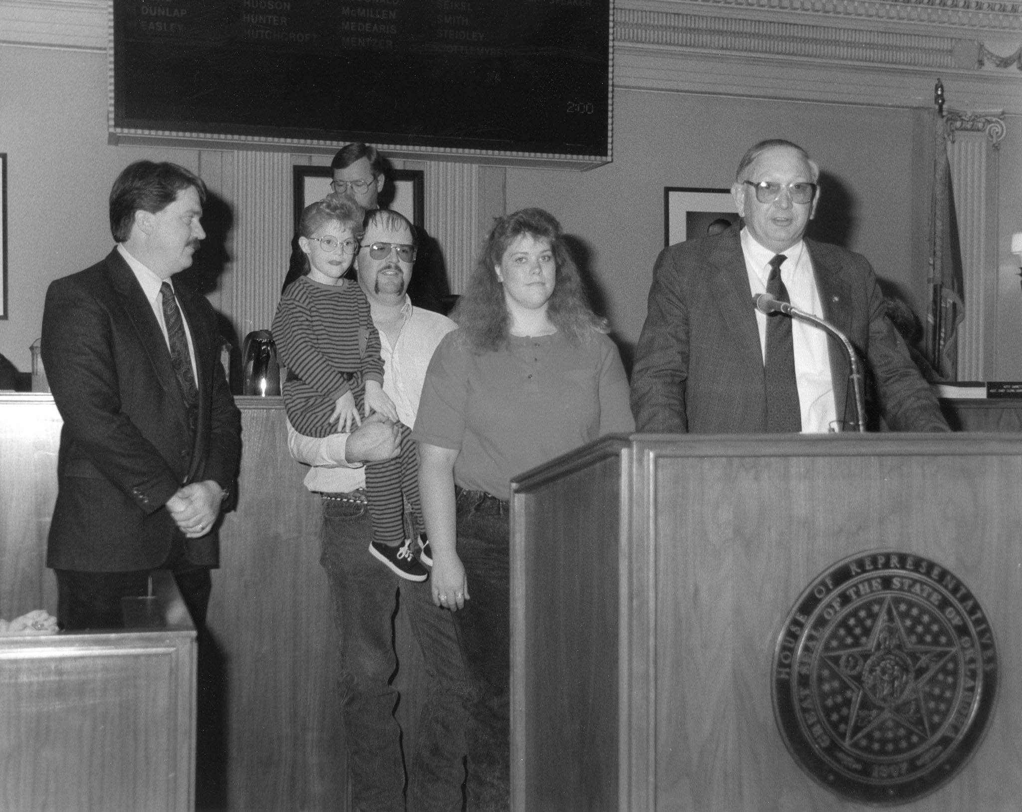 The importance of young farmers and ranchers was recognized in this 1990 photo, in which Rep. Jack Begley (right) presented a citation to the Oklahoma Farm Bureau Young Farm Family of the Year, Texas County’s Monte and Bobbi Smith. Begley read the citation recognizing the family to the House chamber while Speaker of the House Steve Louis (in background) and OKFB’s Director of Governmental Relations Dennis Howard (left) listened. The lawmaker told his counterparts he wanted them to meet an “endangered species – young farmers in Oklahoma.” The Smith family owned a diversified farm and ranch near Texhoma, where they raised cattle and grew wheat, alfalfa and sudangrass.