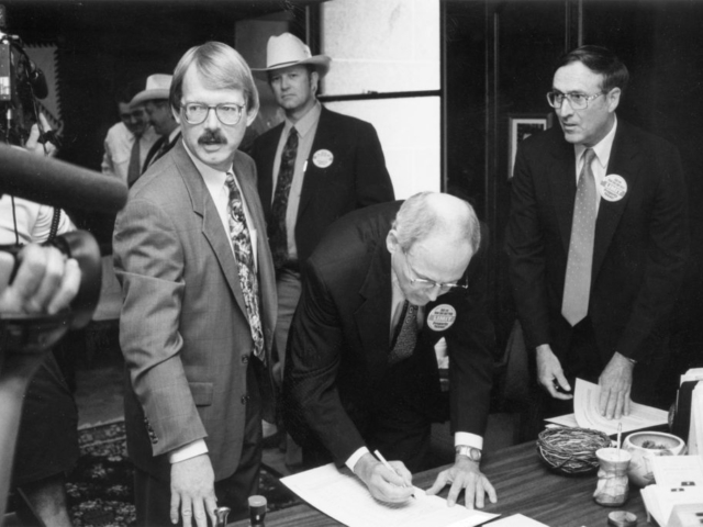 In 1994, Oklahoma Farm Bureau President Eldon Merklin attracted media coverage as he became the first person to sign a petition that would give taxpayers control over ad valorem tax levels. OKFB was part of a coalition that supported placing the Property Owners Protection Act on the ballot. Later, petitions were signed at county Farm Bureau offices. Also pictured at the signing event was Oklahoma Taxpayers Union President Dan Brown, OKFB Board Member Joe Mayer and coalition spokesman Jim Williams.
