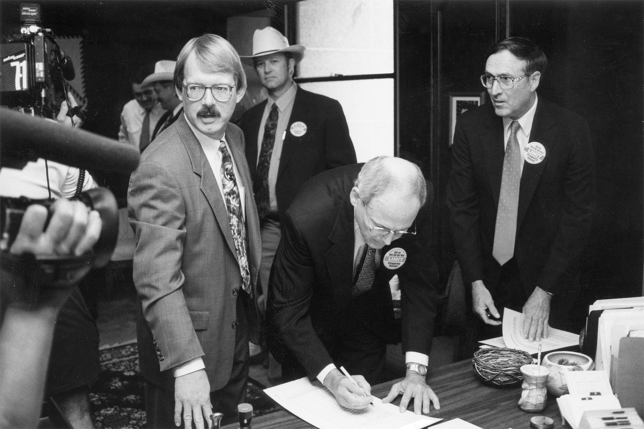 In 1994, Oklahoma Farm Bureau President Eldon Merklin attracted media coverage as he became the first person to sign a petition that would give taxpayers control over ad valorem tax levels. OKFB was part of a coalition that supported placing the Property Owners Protection Act on the ballot. Later, petitions were signed at county Farm Bureau offices. Also pictured at the signing event was Oklahoma Taxpayers Union President Dan Brown, OKFB Board Member Joe Mayer and coalition spokesman Jim Williams.