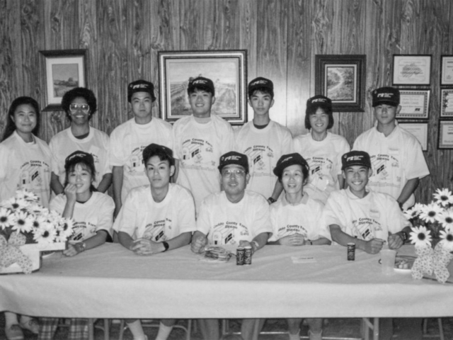 This 1994 photo includes program members from Japan after they enjoyed a home-prepared meal of Indian tacos and exchanged gifts during a stop at the Caddo County Farm Bureau office. The group was also presented with T-shirts and Farm Bureau caps as well as seedless watermelons provided by Sen. Bruce Price. The visiting group presented fans, handkerchiefs and buttons promoting Japan to the county Farm Bureau members.