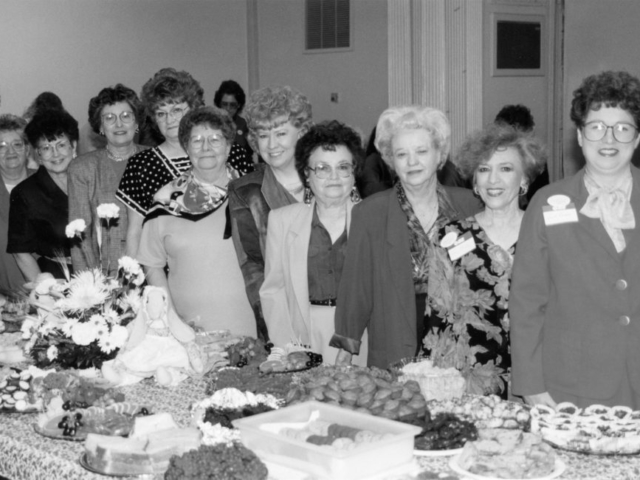 One of the most popular events hosted by the Oklahoma Farm Bureau Women’s Committee is the Farm City Festival. Women from across the state bring home-prepared food, featuring ingredients produced in Oklahoma, to the Oklahoma State Capitol during the legislative session to educate lawmakers and their staff about the Oklahoma agriculture industry. Here, members pause briefly behind their decorated table containing homemade foods before long lines form for the Farm City Festival in 1994. During the event, more than 500 individuals registered in the guest book. Committee members include (left to right): June Kliewer, Doris Lee Howard, Juanita Bolay, Yvonne Phelps, Beverly Delmedico, Sue Jarvis, Chairman Nellie Fern Nelson, Helen Keller and Sarah Henson.