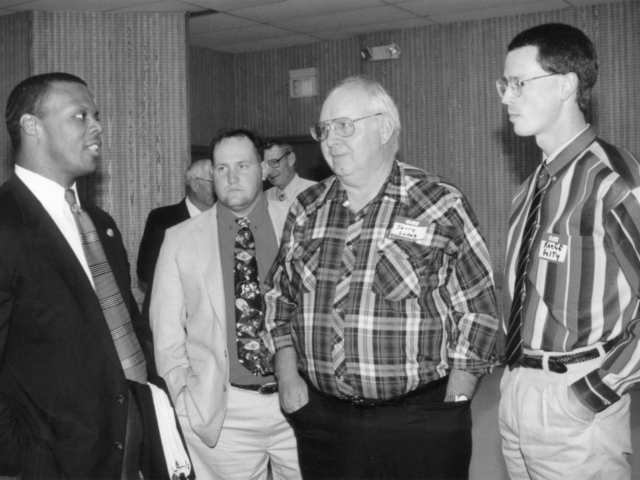 In this photo, U.S. Rep. J.C. Watts visits with Jackson County Farm Bureau members Greg Lucas and Jerry Lucas during the eight-county legislative banquet held in Lawton in 1996. Watts spoke to more than 100 Farm Bureau members, addressing family values, high taxes, the increasing national debt and other issues.
