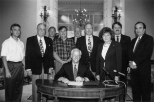 This photo was taken June 12, 1998, as Gov. Frank Keating’s signature on Oklahoma’s estate tax reform bill drew a large crowd of interested witnesses. Attending the ceremony in the Oklahoma State Capitol’s Blue Room were (left to right) OKFB General Counsel Richard Herren, OKFB President Jack Givens, OKFB Executive Director Matt Wilson, Mason Mungle, Rep. Larry Ferguson, Sen. Owen Laughlin, Rep. Mary Easley, Agriculture Commissioner Dennis Howard, and Director of State Finance Tom Daxon.