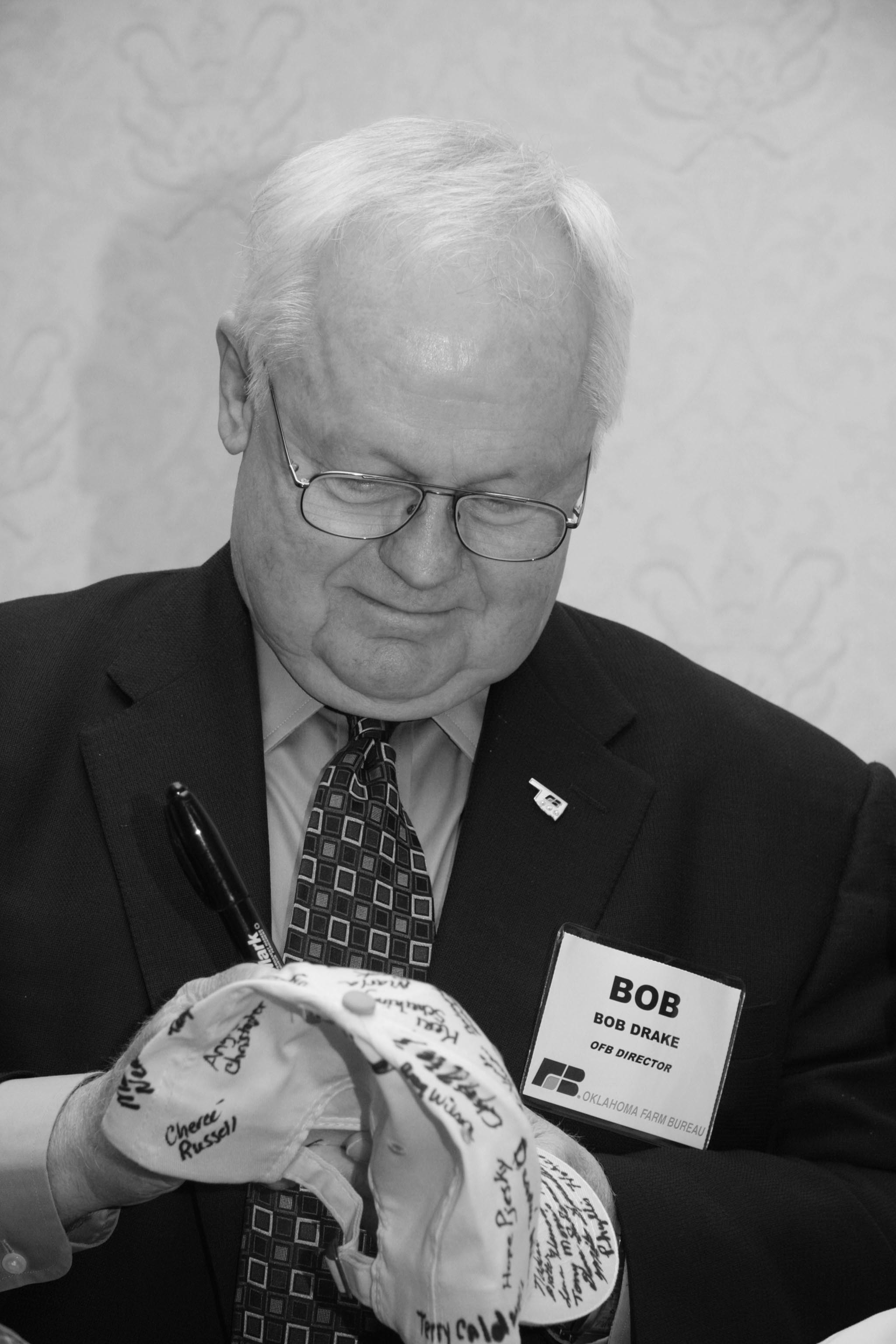 Oklahoma Farm Bureau Board Member Bob Drake of Murray County signs an OKFB cap that was passed around to members at the 2009 State Resolutions Committee meeting, showing support for the American Farm Bureau Federation’s “Don’t cap our future” campaign. The campaign rallied against a proposed “cap and trade” scheme of environmental controls that was being proposed in Congress. Two signed caps were sent to Washington, D.C., to show OKFB support for the campaign, one of which was used on the U.S. Senate floor by Sen. Jim Inhofe during debate on the bill.