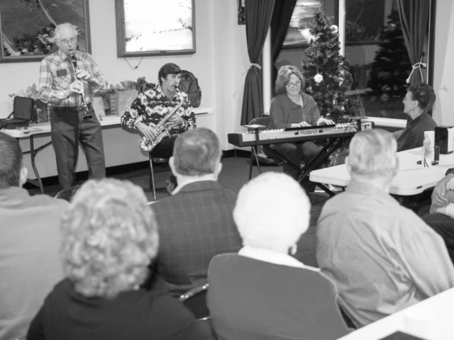 Here, Rogers County Farm Bureau members, including County President E.J. Snider on the clarinet entertain members during the county’s annual Christmas party in 2014, which included a meal and a gift exchange.