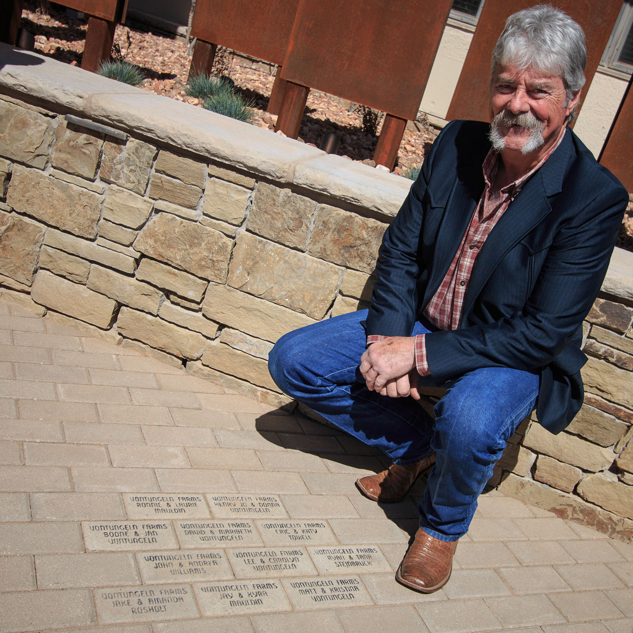 David VonTungeln poses next to brick pavers commemorating his family members' dedication to OKFB.